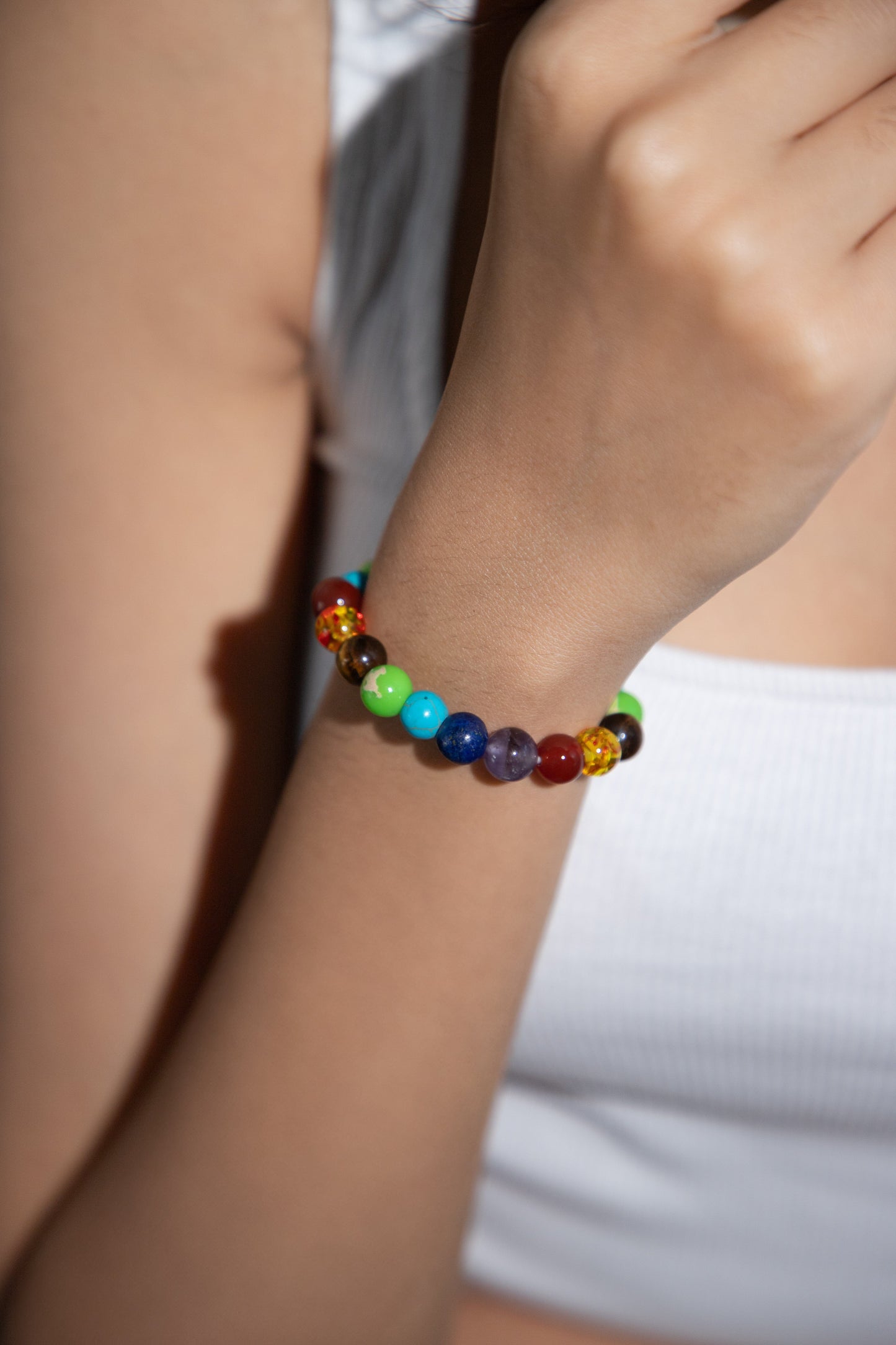 7 chakra beads on a girl's wrist 