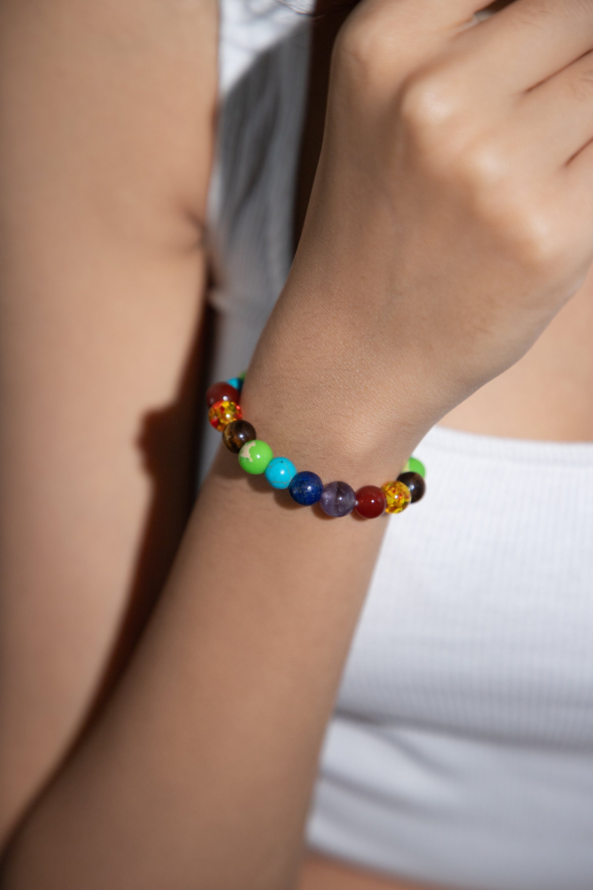7 chakra beads on a girl's wrist 